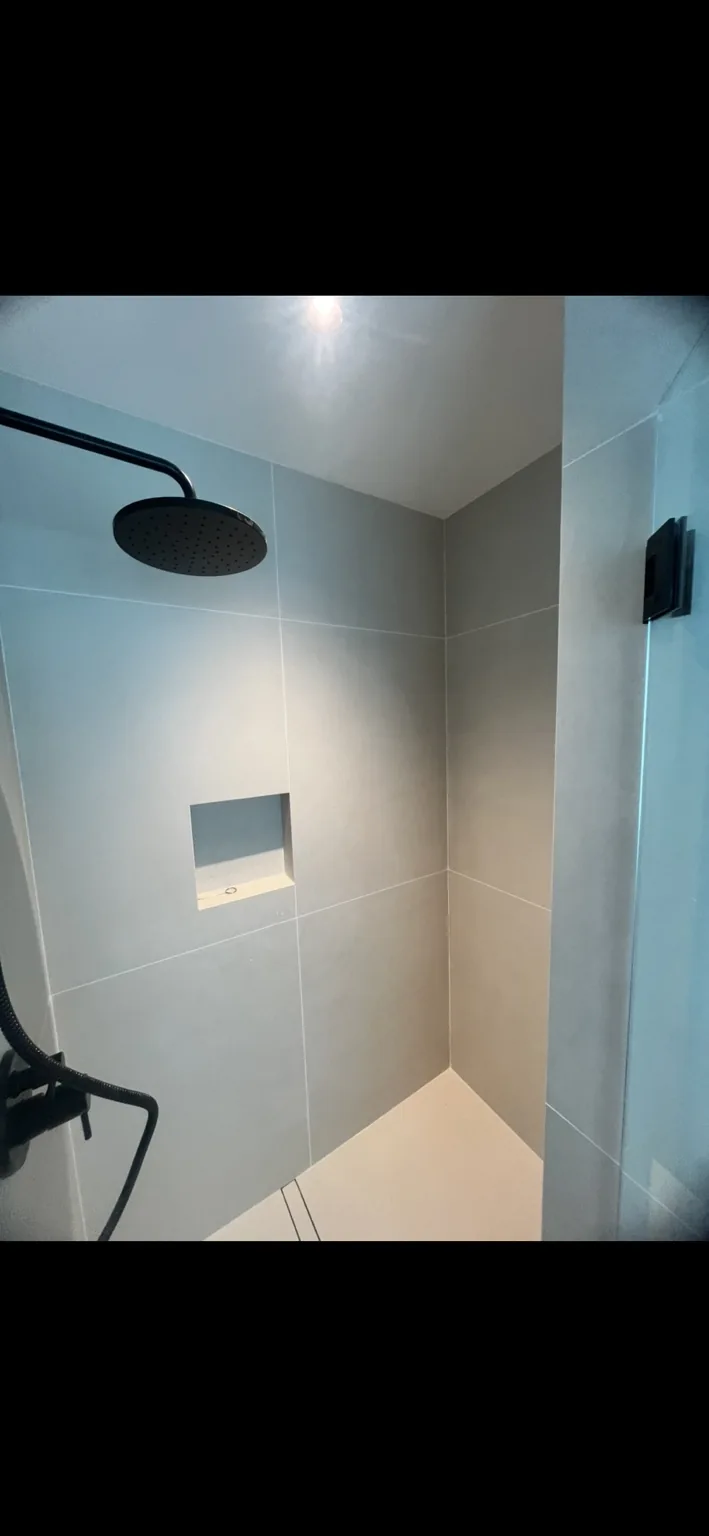 Modern shower with large-format tile and rainfall fixture